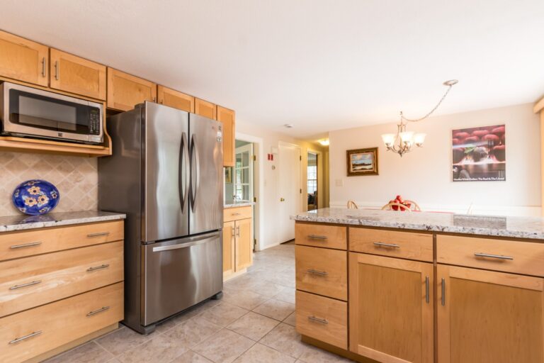 a kitchen features wood cabinets, stainless steel appliances, and granite countertops