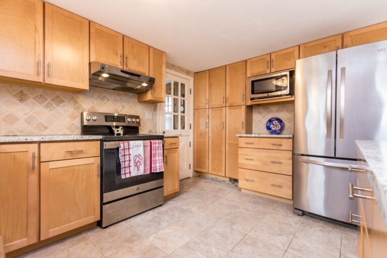 a kitchen features wood cabinets, stainless steel appliances, and granite countertops