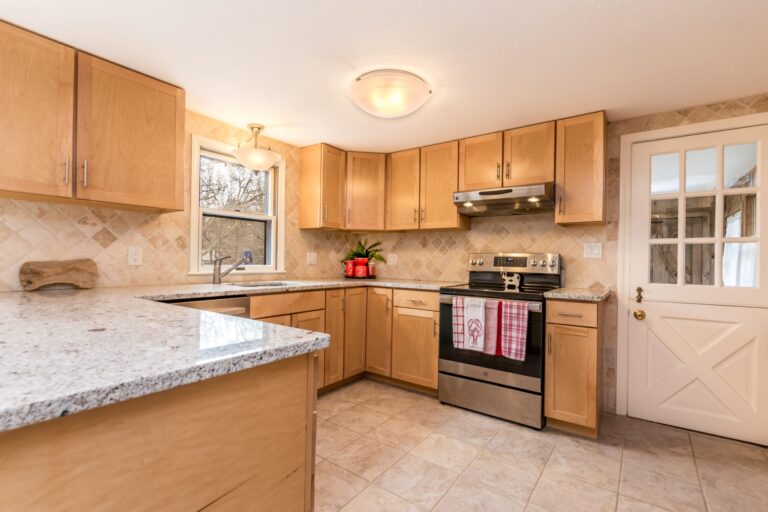 a kitchen features wood cabinets, stainless steel appliances, and granite countertops