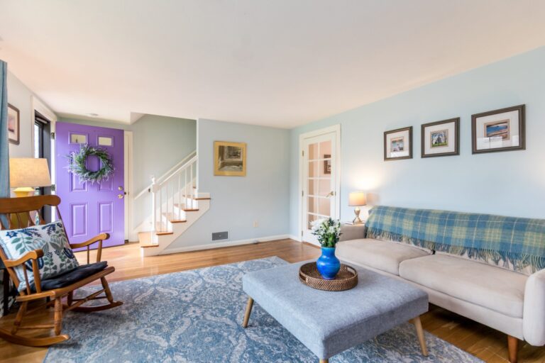a bright and cozy living room featuring hardwood floors and a large patterned area rug
