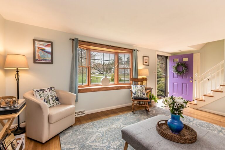 a bright and cozy living room featuring hardwood floors and a large patterned area rug