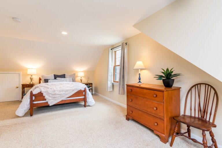 cozy bedroom features a slanted ceiling and a knee wall