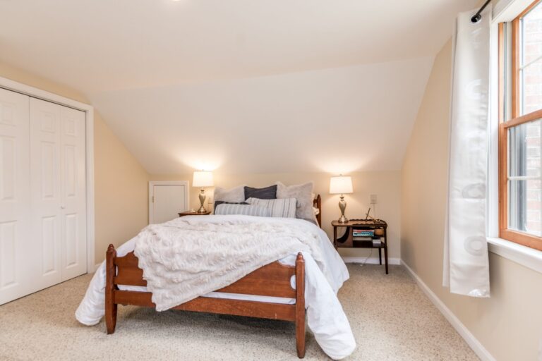 cozy bedroom features a slanted ceiling and a knee wall