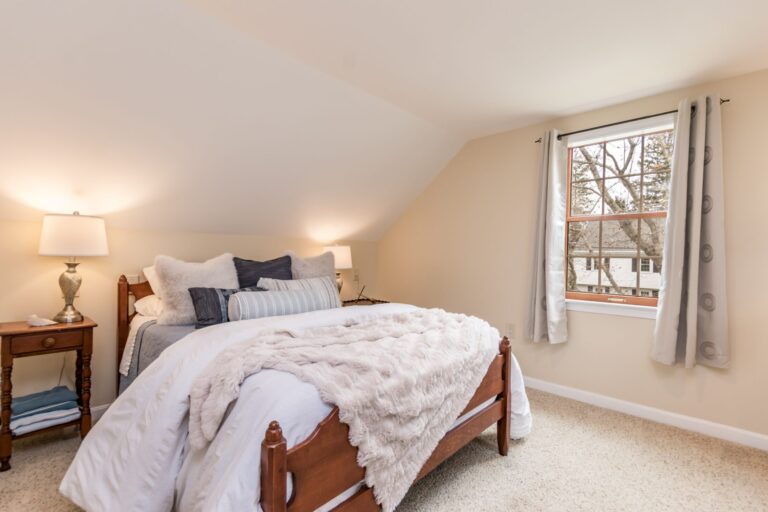 cozy bedroom features a slanted ceiling and a knee wall